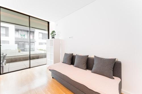 a living room with a couch and glass walls at GuestReady - Amazing Modern home near the beach in Vila Nova de Gaia