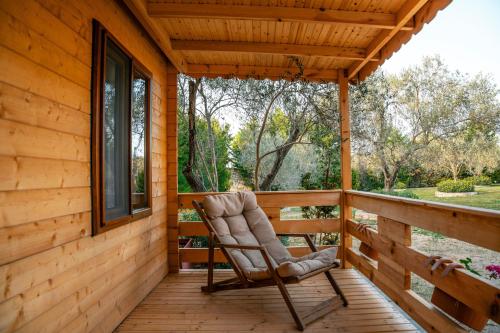 a rocking chair on the porch of a wooden cabin at Bir Dem Urla in Urla
