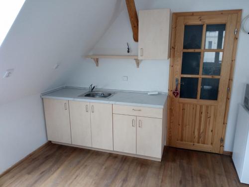 a kitchen with a sink and a wooden door at Chalupa Pod Smědavou in Weissbach