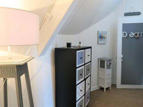 Cette chambre comprend un réfrigérateur noir et une table. dans l'établissement Maison de pêcheur rénovée avec cour et wifi, à 100m du port de Perros-Guirec - FR-1-368-264, à Perros-Guirec