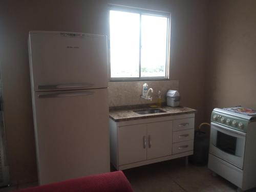 a kitchen with a refrigerator and a sink and a window at Residencial Barbosa - Apto 302 in Macaé