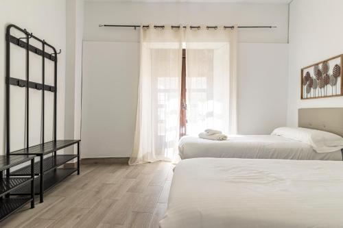 a bedroom with two beds and a window at Allo Apartments Arroyo Catedral in Jerez de la Frontera