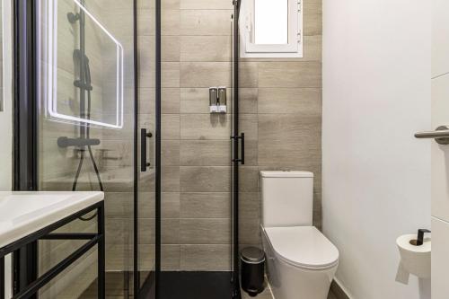 a bathroom with a toilet and a glass shower at Allo Apartments Arroyo Catedral in Jerez de la Frontera