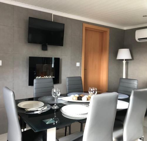 a dining room with a table and chairs and a television at Casa de Vivian and Michael in São Pedro