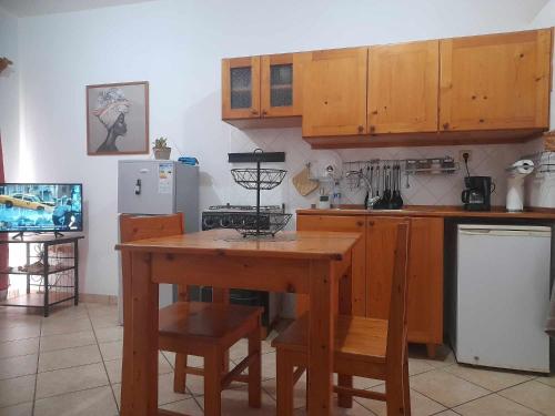 uma cozinha com armários de madeira e uma mesa de madeira em Apto Martins - Prédio Residencial Inês nº23 em Vila do Maio