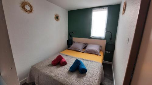 - un petit lit avec deux chaussures bleues et rouges dans l'établissement Appartement 2 pièces mezzanine avec piscine, au Cap d'Agde