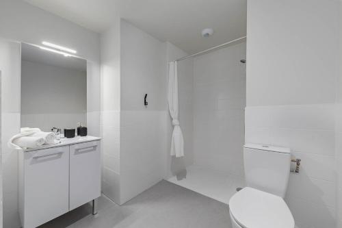 une salle de bain blanche avec douche et toilettes dans l'établissement Student Factory Rouen Champ de Mars, à Rouen