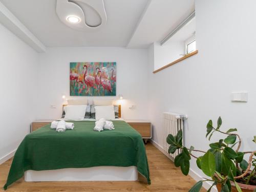 Un dormitorio con una cama verde con toallas. en Espectacular apartamento en el Sardinero, en Santander