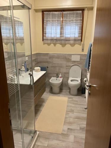 uma casa de banho com um WC, um lavatório e um chuveiro em City Center modern and cozy apartment em Massa