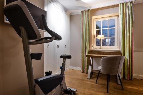 a room with a treadmill and a desk with a window at Strandvogtei Sylt in Rantum