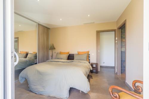 une chambre avec un lit et un grand miroir dans l'établissement San Quilico - Maison climatisée piscine vue mer, à Aregno