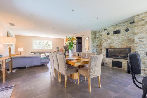 Un comedor y una sala de estar con mesa y sillas. en San Quilico - Maison climatisée piscine vue mer, en Aregno