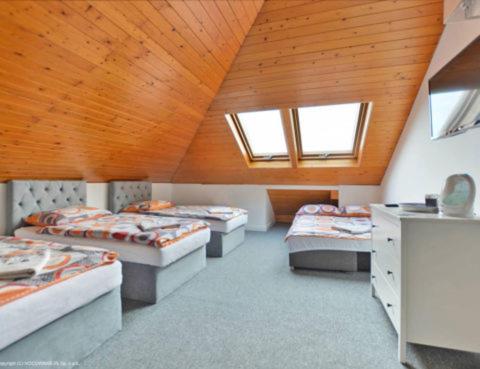 Habitación con 4 camas en una habitación con ventanas en Pokoje Gościnne Bryza Gdynia, en Gdynia