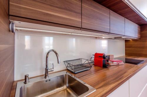 - un comptoir de cuisine avec un évier et un appareil rouge dans l'établissement COLBERT - Appartement 80M2 proche du vieux-port, à Marseille
