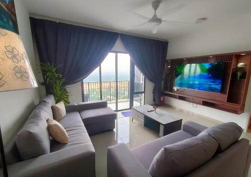 a living room with a couch and a flat screen tv at Cozy 3R2B Relax Stay with Amaze Landscape #SR1 in Teluk Panglima Garang