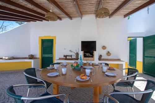 a dining room with a wooden table and chairs at Quinta Molinum Ad Mare by Algarve Holidays in Boliqueime