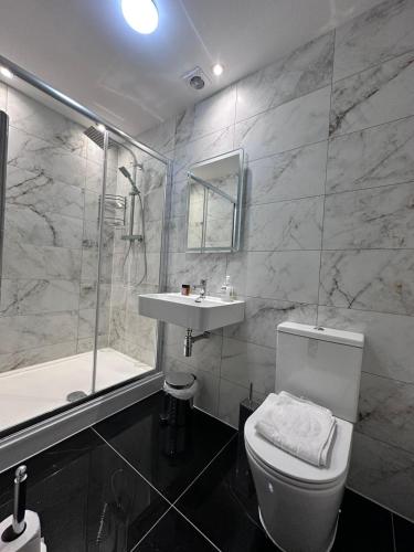 a bathroom with a toilet and a sink and a shower at Acacia Hotel in London