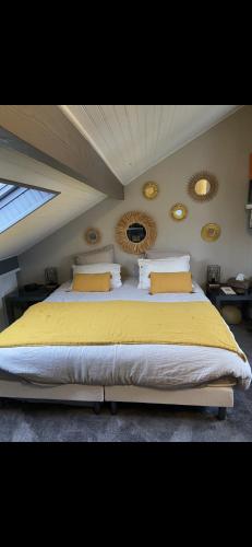 Un dormitorio con una cama grande con sábanas amarillas. en Maison conviviale de caractère, en Colombes