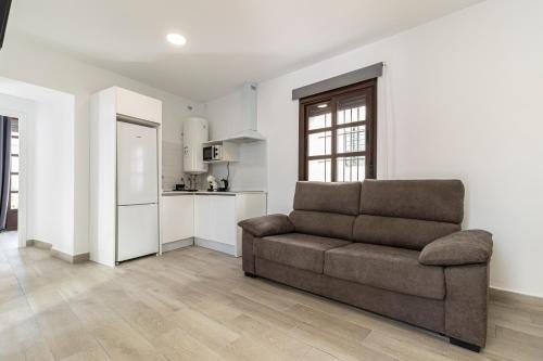 a living room with a couch and a kitchen at Allo Apartments Arroyo Catedral in Jerez de la Frontera