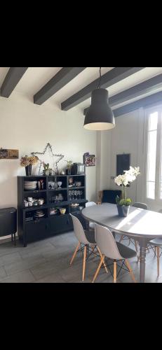 une salle à manger avec une table et des chaises blanches dans l'établissement Maison conviviale de caractère, à Colombes