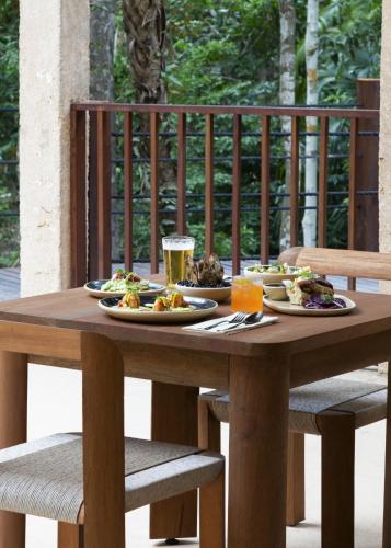 a wooden table with plates of food on it at Boca de Agua Bacalar in Bacalar
