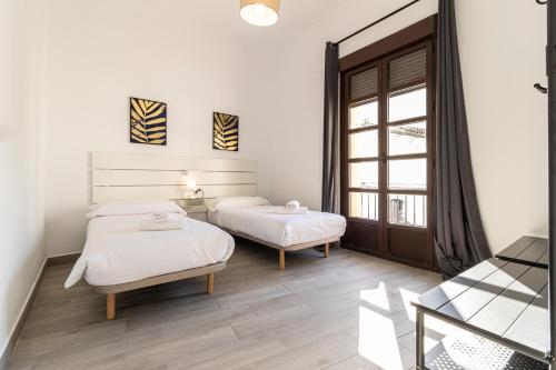 a bedroom with two beds and a window at Allo Apartments Arroyo Catedral in Jerez de la Frontera