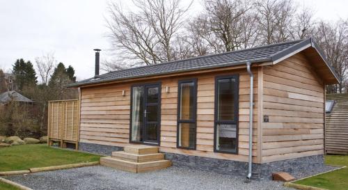 Cabaña de madera pequeña con techo a dos aguas en Braidhaugh Holiday Lodge and Glamping Park, en Crieff