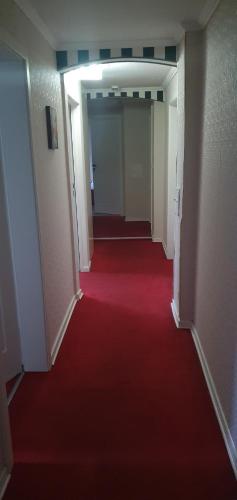 a hallway with a red carpet and a red floor at Alte-post in Wissen