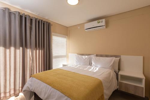 Schlafzimmer mit einem Bett und einem Fenster in der Unterkunft Kgaba Villas in Ramotswa