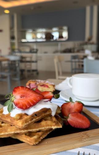 a plate of waffles with strawberries on a table at Hotel Panorama in Cattolica