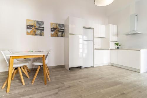 a kitchen with a table and chairs and a refrigerator at Allo Apartments Arroyo Catedral in Jerez de la Frontera