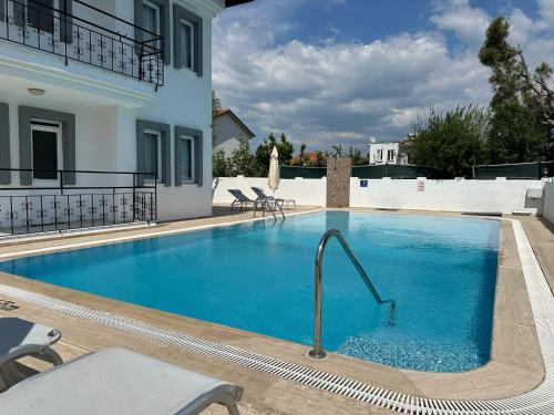 a large blue swimming pool next to a building at Stay Dalyan Apart Hotel in Ortaca