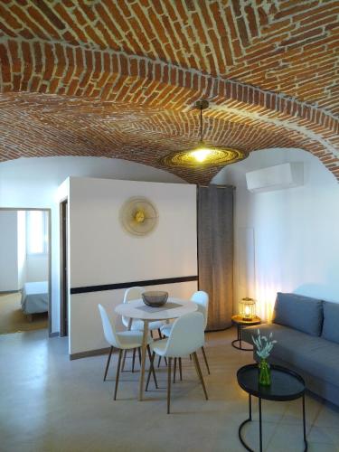 un salon avec une table, des chaises et un canapé dans l'établissement chez Angèle, à Aléria