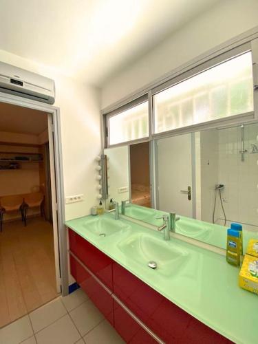 une salle de bain avec un lavabo et un grand miroir dans l'établissement Splendide VILLA 4 Chambres Piscine Classée 4 Etoiles, à Montpellier