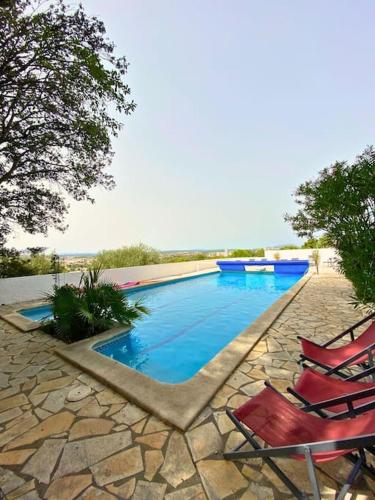 - une piscine avec 2 chaises longues à côté dans l'établissement Splendide VILLA 4 Chambres Piscine Classée 4 Etoiles, à Montpellier