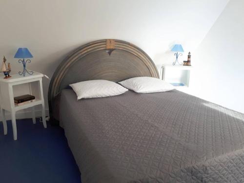 une chambre avec un grand lit et deux tables de nuit dans l'établissement Maison 2* à 100m de la plage avec WIFI, terrasse fleurie, parking gratuit - Perros-Guirec - FR-1-368-279, à Perros-Guirec