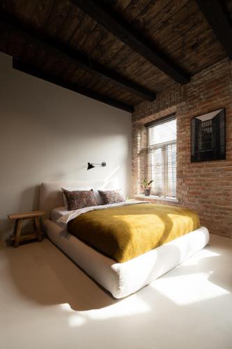 a bedroom with a large bed in a brick wall at Hortus Vilnius in Vilnius