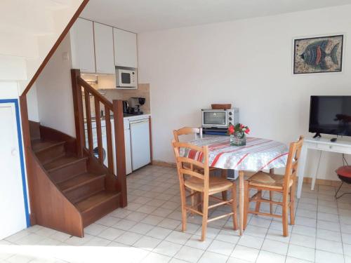 une cuisine et une salle à manger avec une table et des chaises dans l'établissement Maison 2* à 100m de la plage avec WIFI, terrasse fleurie, parking gratuit - Perros-Guirec - FR-1-368-279, à Perros-Guirec