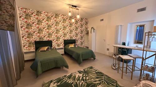 Cette chambre dispose de 2 lits et d'un mur avec du papier peint. dans l'établissement COMFORT ACCOMMODATION SUITE, à Bergame