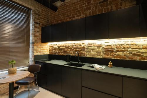 - une cuisine avec un évier et un mur en briques dans l'établissement Hortus Vilnius, à Vilnius