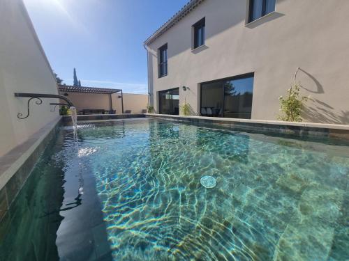 een zwembad voor een huis bij Le Mas des Cigales in Saumane-de-Vaucluse