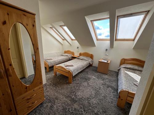 a room with three beds and a mirror and windows at Keta in Marijampolė
