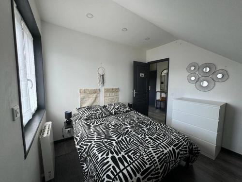 a black and white bed in a white bedroom at ARconciergerie Logement cosy centre-ville in Maisse