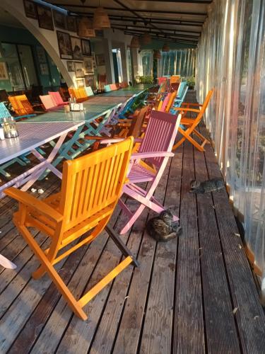 a row of colorful chairs sitting on a wooden deck at Relaks w Marina Cape 88 in Aheloy