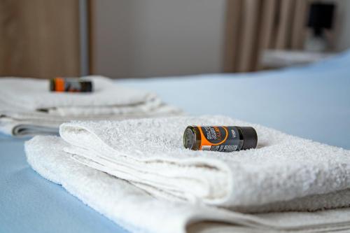 Una botella de alcohol sentada en un montón de toallas. en Nefeli Rooms, en Agia Marina de Nea Kydonia
