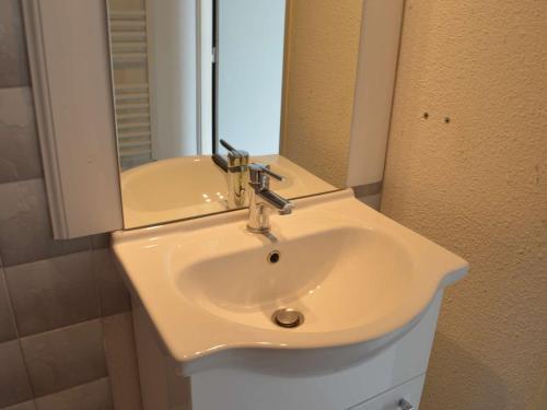 un lavabo blanc dans une salle de bain avec un miroir dans l'établissement Studio climatisé 4 couchages proche plage et commerces au Grau-du-Roi - FR-1-250-160, au Grau-du-Roi