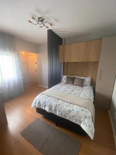 um quarto com uma cama grande em um quarto em Studio central com Garagem em Pelotas