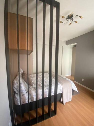 um berço preto num quarto com uma cama em Studio central com Garagem em Pelotas