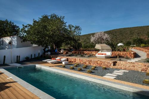 een zwembad in een tuin met stoelen en een tafel bij Glamping Casa Esteval in Rocha Amarela