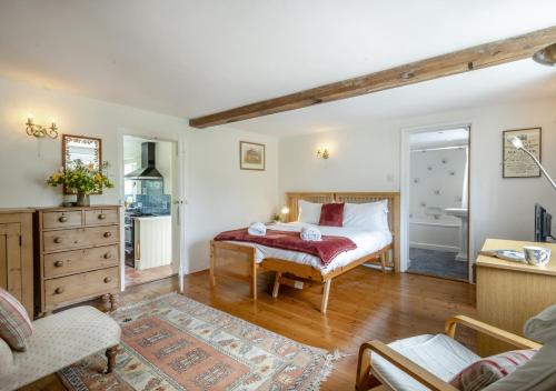 a bedroom with a bed and a living room at Clare Cottage in Melton Constable
